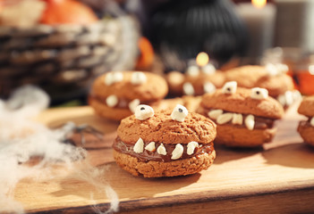 Creative cookies prepared for Halloween party on wooden board