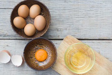 Egg yolk in wooden bowl on wood background