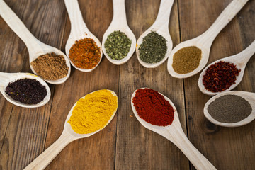 Assorted spices on wooden spoons. Delicious food ingredients.