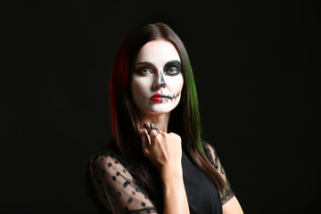 Beautiful woman dressed for Halloween on dark background