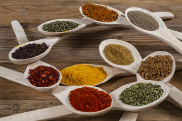Assorted spices on wooden spoons. Delicious food ingredients.