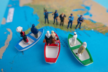 Miniature people concept of Middle Eastern people arrive by boat to the border of USA.