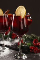 Glasses of delicious mulled wine on grey table