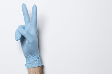 Human hand with blue glove on a light background