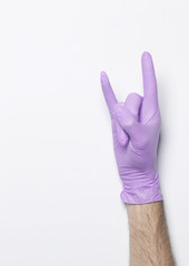 Blue latex medical gloves on a female hand, shows the character okay