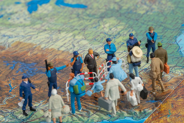 Miniature toy people concept US border patrols against a group of migrant from Mexico