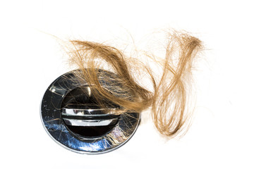 Hair loss on washbasin. Long brown hair on white basin in the bathroom.