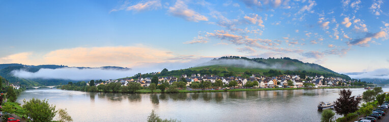 Fototapeta na wymiar Beautiful 180 degree panoramic sunrise view of the river Moselle at the small wine growing town Zell (an der Mosel) on a summer morning