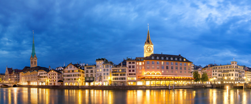 Beautiful panorama of the city of Zurich, Switzerland, at the river Limmat in the blue hour with the Fraum&uuml;nster and St. Peter churches on the skyline