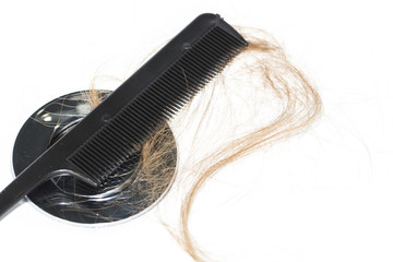 Hair loss on washbasin. Long brown hair with black comb on white basin in the bathroom.