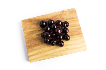 group of fresh red cherries on a wooden board on a white background
