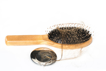 Hair loss on washbasin. Long brown hair with wood brush on white basin in the bathroom.