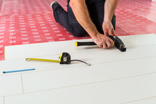 Handyman installing new laminated wooden floor