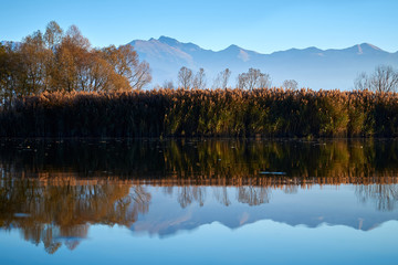 Beautiful autumn landscape with mountains and river reflection 