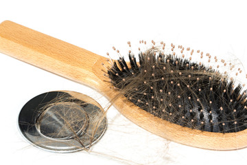 Hair loss on washbasin. Long brown hair with wood brush on white basin in the bathroom.