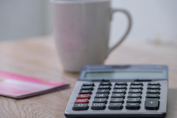 calculator, bankbook ,coffee cup  Put on a wooden table.