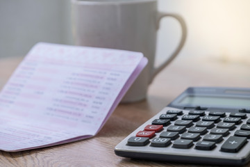 calculator, bankbook ,coffee cup  Put on a wooden table.