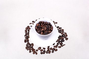 The white cup is filled with coffee beans