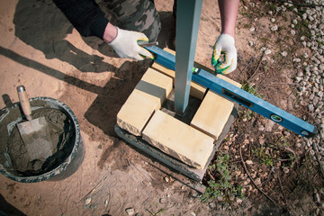 The worker lays bricks on the construction site