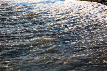 Waves at sea in the rays of sunset