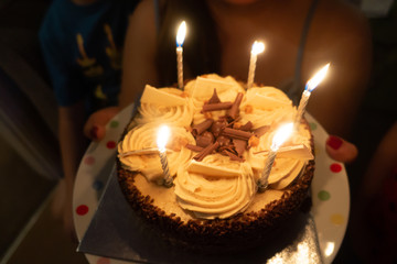 A chocolate birthday cake with candles.
