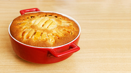 Homemade pastry - pie with apples on wooden table. Angle view with copyspace. Shallow focus.