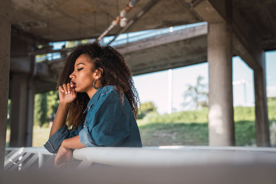 Young woman standing at balcony near railing