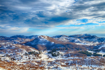 Montenegro. Mountain tops in the snow on a sunset background