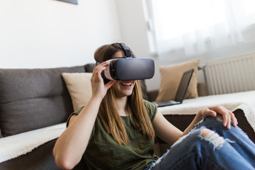 Beautiful young woman enjoying virtual reality at her home.