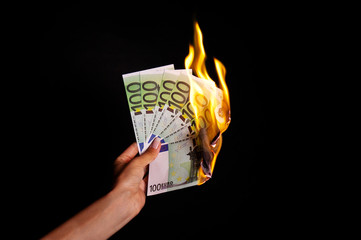 Beautiful Woman Hand Holding Burning Euro Currency Paper Money On Black Wall Background