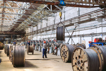 Wire rod, fittings in warehouses. worker alongside a bundle with catalkoy. industrial storehouse at the metallurgical plant. © davit85