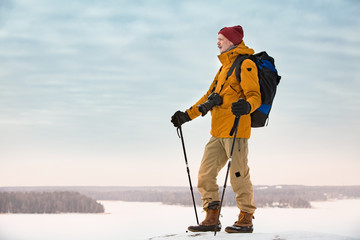 Portrait of mature man with grey beard exploring Finland in winter. Traveler Taking pictures on the...