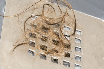 Hair loss in the shower. Long wet brown hair on the railing of the shower in the bathroom.