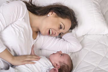 Mother and baby on a white bed