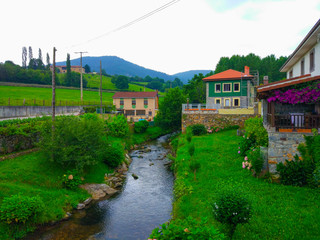 Fototapeta na wymiar Soto river through small village in middle of the field. Paladin, Asturias, Spain. Camino de Santiago Primitivo