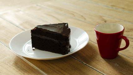 Chocolate cake and Red coffee hot drink on wooden table backgrounds