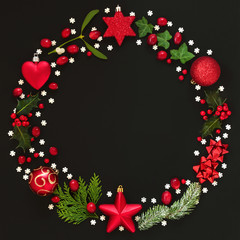 Abstract Christmas wreath garland with winter flora and bauble decorations on black background. Top view.