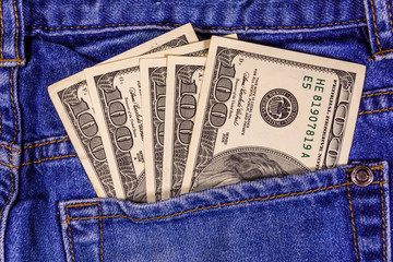 American one hundred dollar banknotes in a pocket of blue jeans