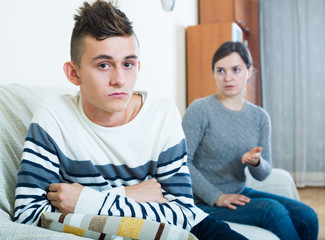 Adult woman lecturing unpleased teenager in home interior