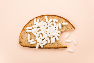 Bitten a piece of bread with Pills of vitamins and trace elements.