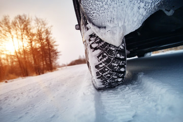 Car tires on winter road covered with snow. Vehicle on snowy way in the morning at snowfall © candy1812