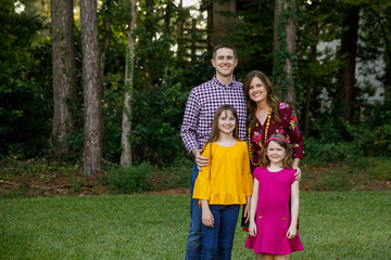 Fototapeta premium Nuclear Family of Four with Daughters Outside in their Backyard