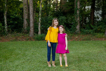 Fototapeta premium Beautiful Sisters in Their Backyard Hugging