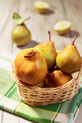 Fresh pears in wicker basket on wood table