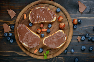 Bread with chocolate spread, chocolate pieces and filbert nuts, top view
