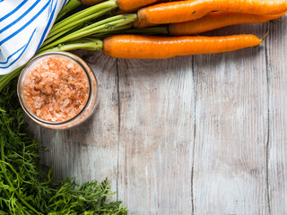 Raw carrots on rustic wooden background. Cooking vegetables