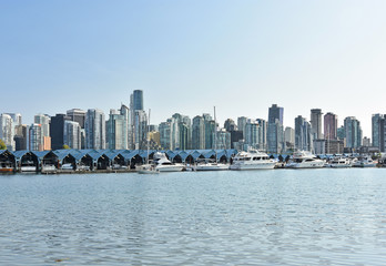 Obraz premium The skyline of Vancouver from Stanley Park at a sunny summer day. Water area with a marina in the foreground. British Columbia, Canada.
