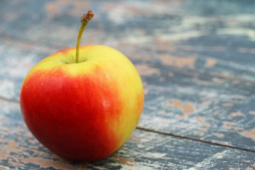 Red and yellow apple on rustic wooden surface with copy space
