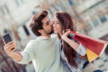 Happy couple taking selfie after shopping