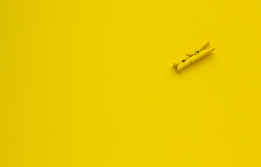 Clothespin on a yellow background, space for text
